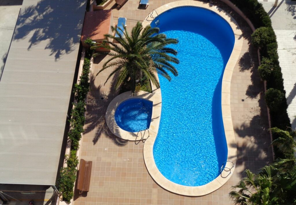 Imagen de la piscina en el apartamento Oasis 8D en Calpe, un oasis refrescante y atractivo donde los huéspedes pueden sumergirse en la diversión y el relax, disfrutando del sol y el agua en un entorno tranquilo y rejuvenecedor