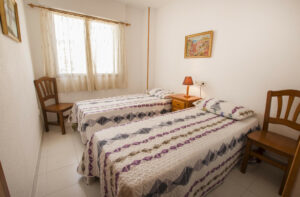 Imagen del dormitorio en el apartamento "Conchas" en Calpe, un espacio acogedor y bien diseñado con camas cómodas, ofreciendo un refugio perfecto para familias en busca de unas vacaciones relajantes y rejuvenecedoras
