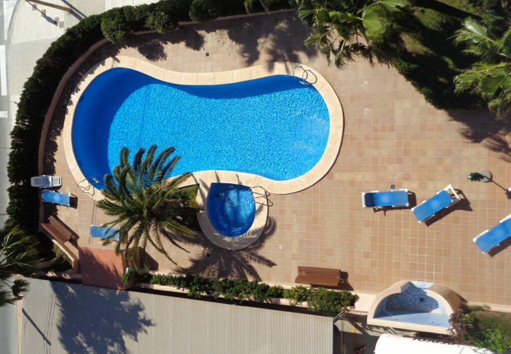 Imagen de la piscina en el apartamento Oasis 8D en Calpe, un refugio refrescante y atractivo con aguas cristalinas, donde los huéspedes pueden sumergirse en la diversión y el relax, disfrutando de momentos inolvidables bajo el sol en un entorno tranquilo y rejuvenecedor.