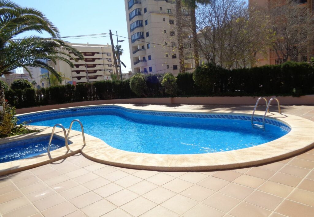 Imagen de la piscina en el apartamento Oasis 8D2 en Calpe, mostrando un oasis refrescante y atractivo con aguas cristalinas, donde los huéspedes pueden sumergirse en la diversión y el relax, disfrutando del sol y el agua en un entorno tranquilo y rejuvenecedor