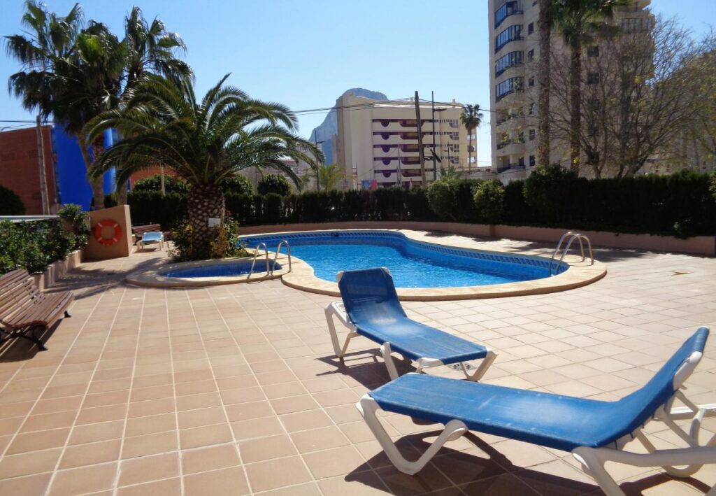 Imagen horizontal de la piscina en el apartamento Oasis 8D en Calpe, mostrando una vista atractiva y refrescante del área de la piscina, donde los huéspedes pueden nadar, tomar el sol y disfrutar de momentos de diversión y relajación en un entorno hermoso.